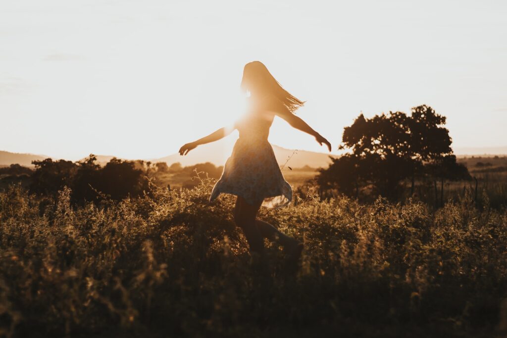 Life should be stress free. A woman dances in a field.
